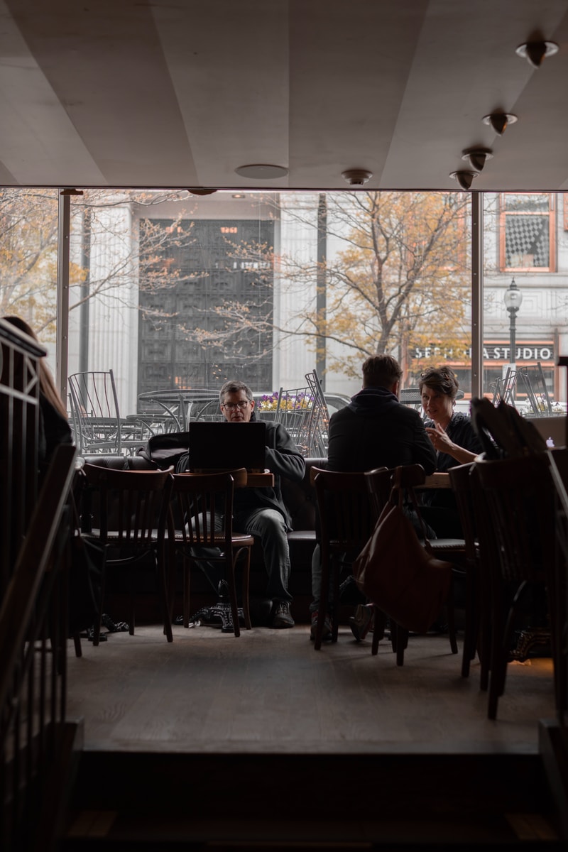 man sitting near the window photography